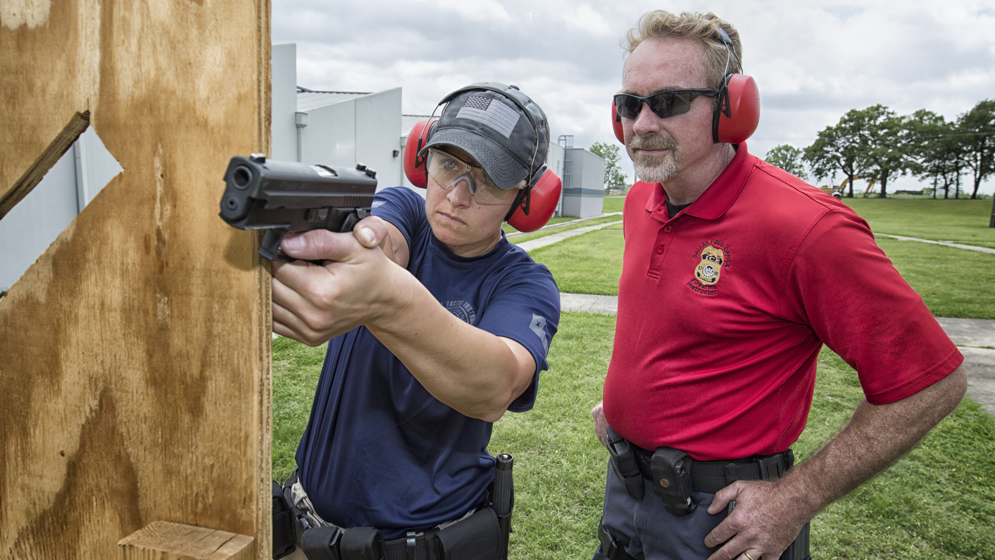 La oficial supervisora de detención y deportación Kelei Walker recibe instrucciones en el polígono de tiro del instructor de armas de fuego Gerald Hutt en Dallas, Texas.
