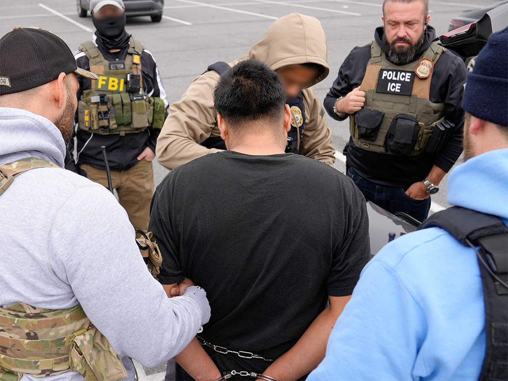 U.S. Immigration and Customs Enforcement Field Office Director Matt Elliston and a team of federal law enforcement officers from the FBI, the ATF and other agencies take an alleged MS-13 member into custody during an enhanced enforcement operation near Baltimore Feb. 5.