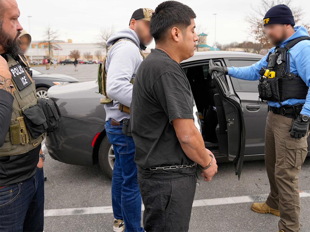 U.S. Immigration and Customs Enforcement Field Office Director Matt Elliston and a group of federal law enforcement officers take an alleged MS-13 member into custody during an enhanced enforcement operation near Baltimore Feb. 5.