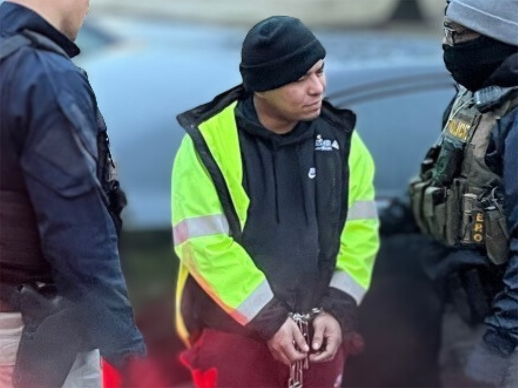 Federal law enforcement officials talk to an MS-13 member after his arrest during an enhanced enforcement operation near Baltimore Feb. 6.