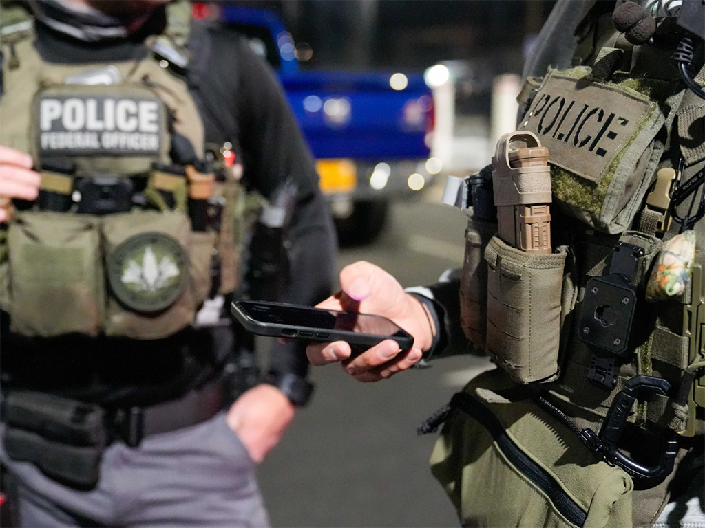 Two federal law enforcement officers coordinate with other officials on the ground during an enhanced immigration enforcement operation near Washington, D.C. in the early morning hours of Feb. 4.