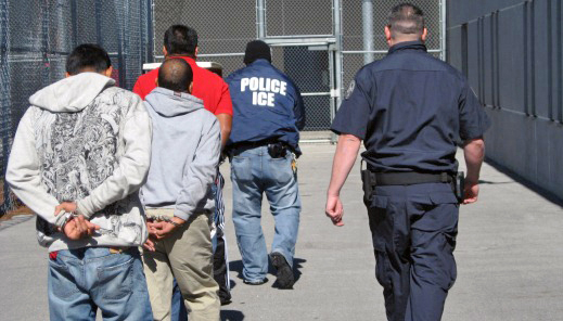 ICE agents escort three of the 95 arrested individuals towards incarceration
