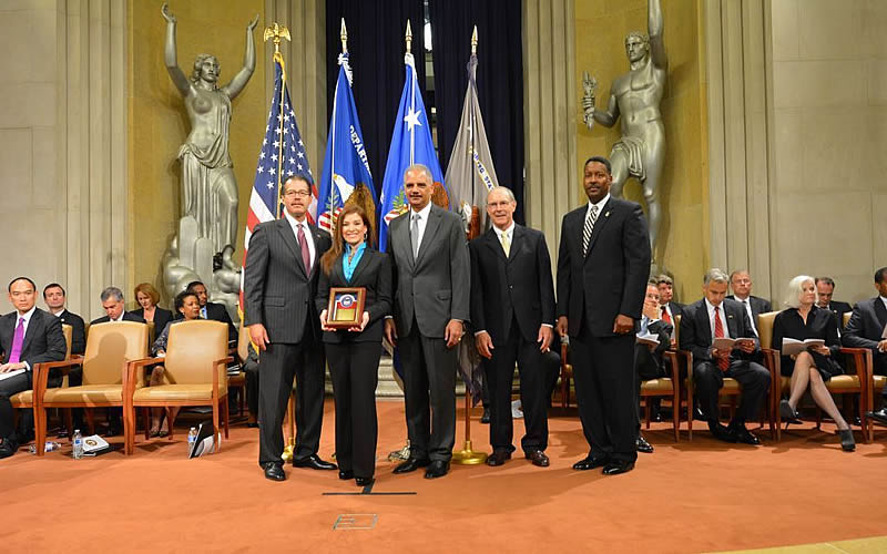 Special Agent Liza Lugo, HSI Tucson, receives an award from U.S. Attorney General Eric Holder with HSI Executive Associate Director Peter Edge (right). 